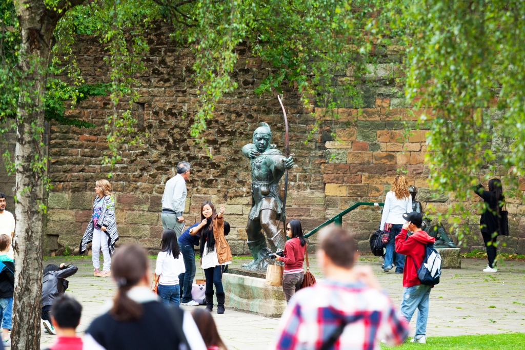 people next to a statue of robin hood
